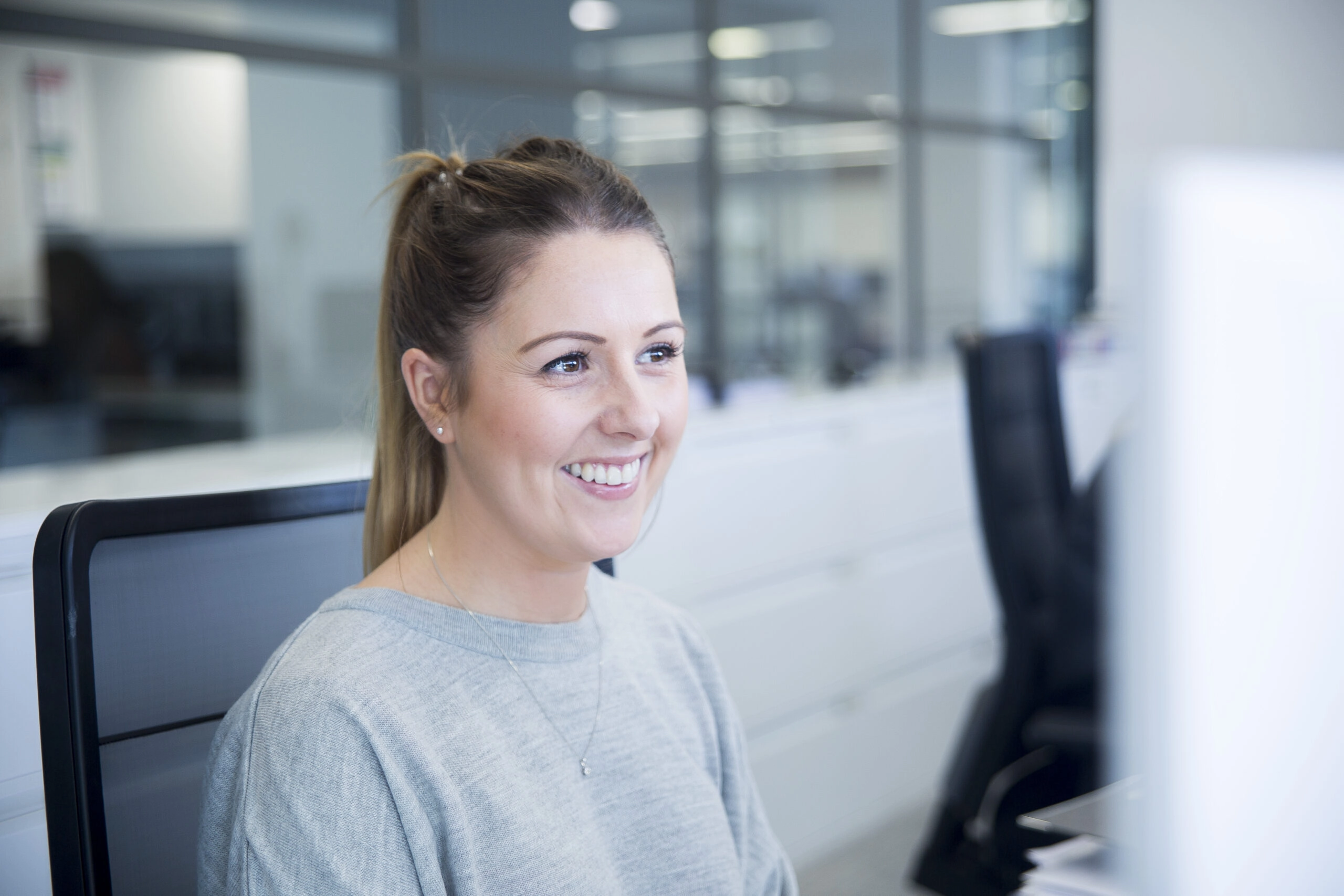 Samantha Cottle from Clarksons smiling at her computer screen while using UpSlide’s brand compliance software