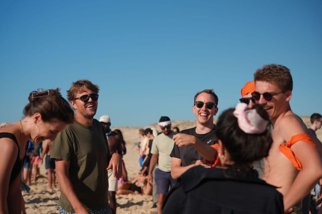 Un groupe d'employés de UpSlide riant ensemble à la plage.