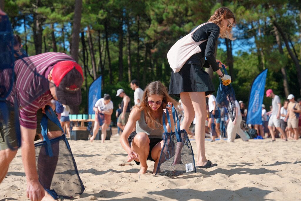 Une employée de UpSlide ramassant des déchets sur une plage.