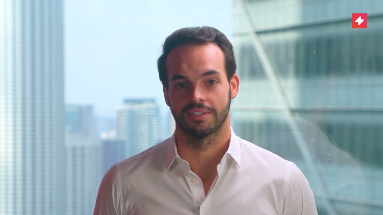 Screenshot from a video showing a man, Thomas Roland from UpSlide, in a white shirt.